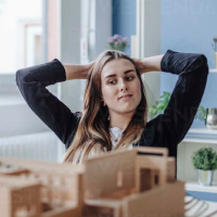 portrait-of-young-architect-looking-at-architectural-model-in-office-GUSF00600 1